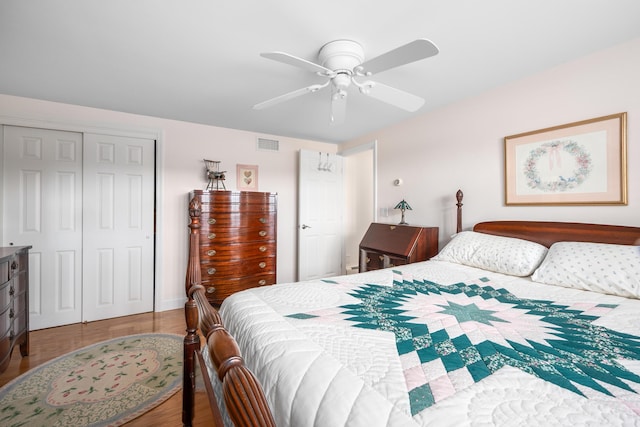bedroom with a closet, wood finished floors, and a ceiling fan