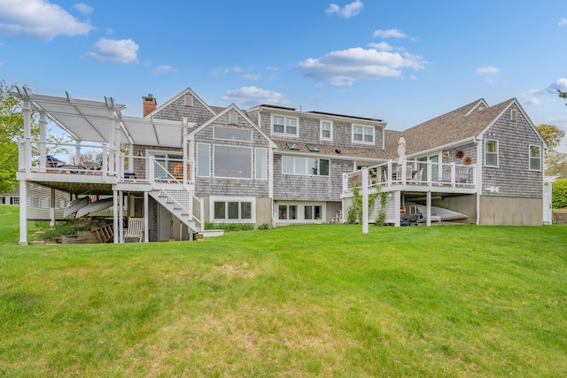 rear view of property featuring stairs, a wooden deck, a lawn, and a chimney