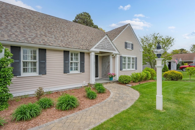 view of front facade featuring a front lawn and a shingled roof