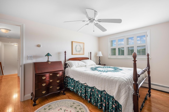 bedroom with wood finished floors, baseboards, a ceiling fan, and a baseboard radiator
