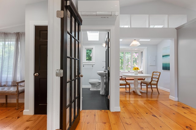 280 Schoolhouse Rd, Eastham, MA 02642 - corridor featuring a skylight, light wood-style floors, a wall mounted air conditioner, and baseboards