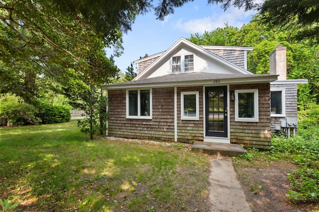 280 Schoolhouse Rd, Eastham, MA 02642 - view of front of property featuring a chimney, a front yard, and roof with shingles