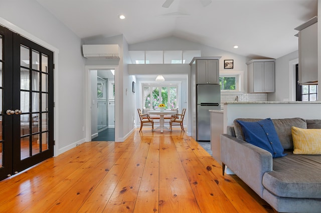 280 Schoolhouse Rd, Eastham, MA 02642 - kitchen featuring freestanding refrigerator, gray cabinets, an AC wall unit, vaulted ceiling, and light wood-style floors