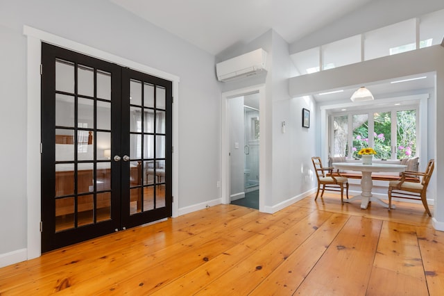 280 Schoolhouse Rd, Eastham, MA 02642 - dining space with an AC wall unit, french doors, hardwood / wood-style floors, and baseboards