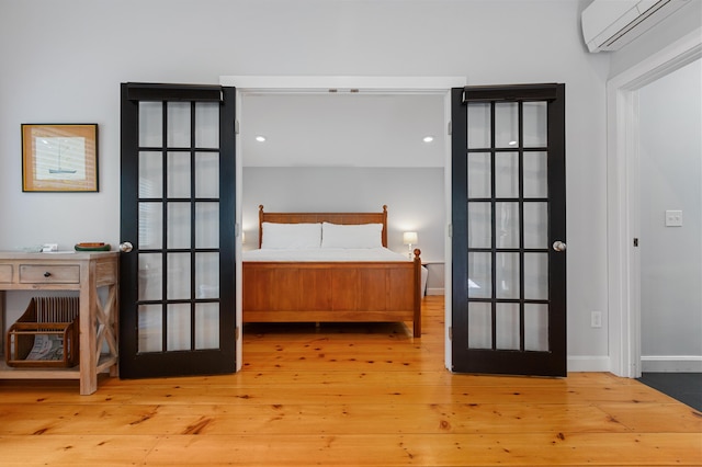 280 Schoolhouse Rd, Eastham, MA 02642 - bedroom featuring an AC wall unit, wood-type flooring, french doors, and baseboards