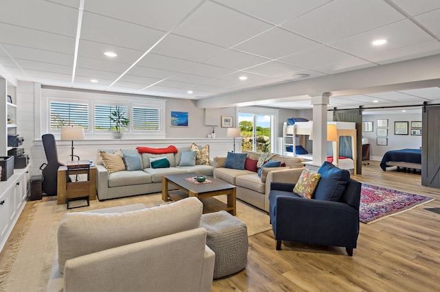 27 Gully Ln, East Sandwich, MA 02537 - living room with a barn door, light wood-style flooring, a drop ceiling, and recessed lighting