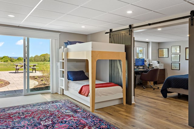 27 Gully Ln, East Sandwich, MA 02537 - bedroom featuring a barn door, access to outside, light wood finished floors, a drop ceiling, and multiple windows