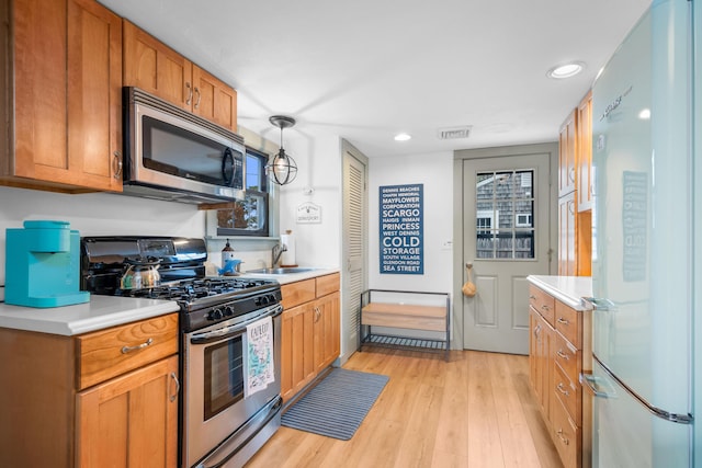 22 Wixon Rd, Dennis Port, MA 02639 - kitchen featuring appliances with stainless steel finishes, light countertops, light wood-type flooring, recessed lighting, and brown cabinetry