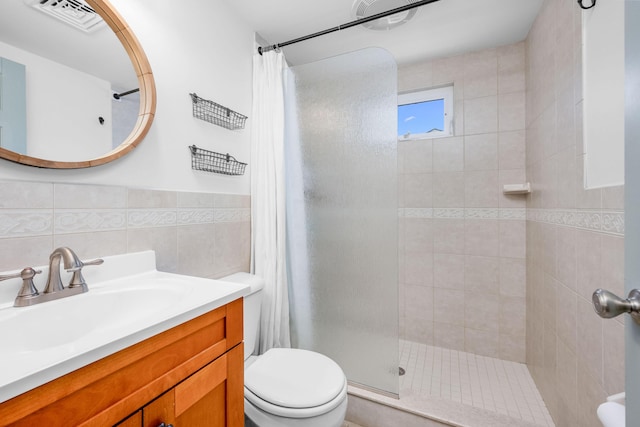 22 Wixon Rd, Dennis Port, MA 02639 - bathroom featuring a tile shower, vanity, tile walls, and a wainscoted wall