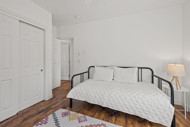 bedroom featuring a closet, baseboards, and wood finished floors