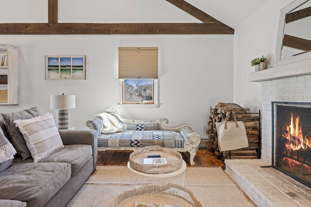 living room featuring a brick fireplace, beamed ceiling, and wood finished floors