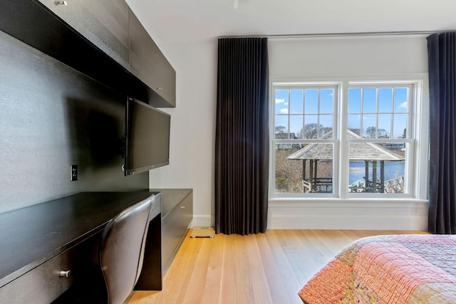 bedroom with light hardwood / wood-style floors and built in desk