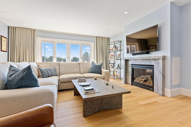 living room with light hardwood / wood-style floors and a premium fireplace