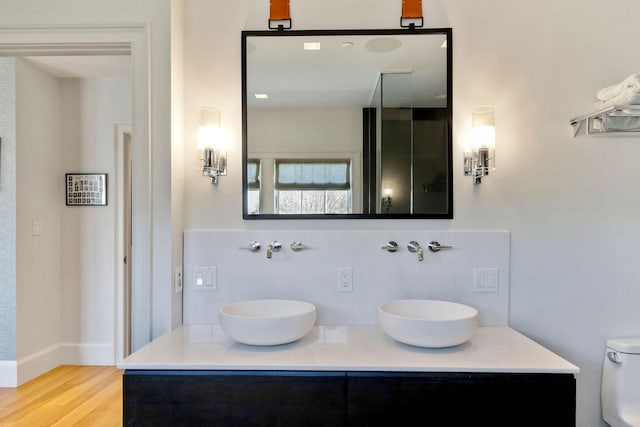 bathroom featuring hardwood / wood-style flooring, backsplash, toilet, and vanity