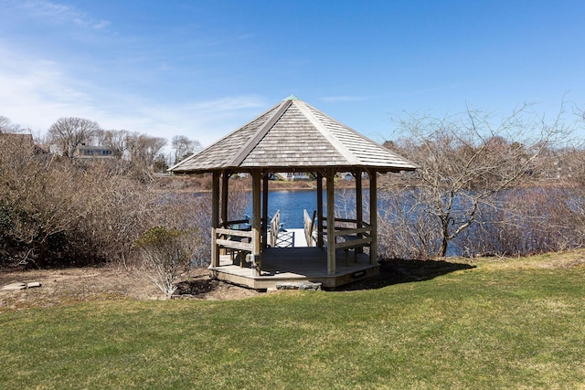 dock area with a water view, a gazebo, and a lawn