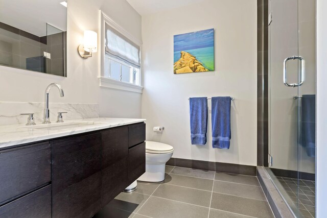 bathroom with an enclosed shower, tile patterned floors, vanity, and toilet