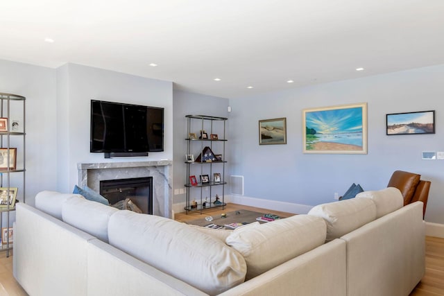 living room with light hardwood / wood-style flooring and a high end fireplace