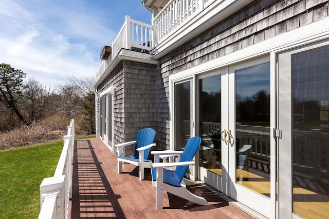 exterior space with a balcony, a wooden deck, and french doors