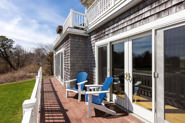 exterior space with a balcony, a wooden deck, and french doors