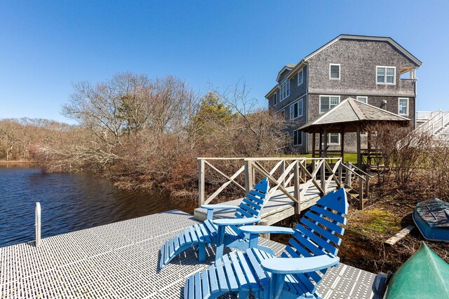 view of dock with a gazebo and a water view