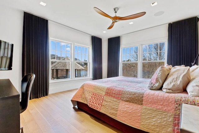 bedroom with multiple windows, light wood-type flooring, and ceiling fan