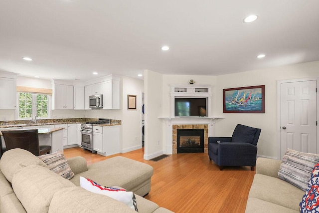 33 Beach Rd, Orleans, MA 02653 - living room with light wood-style floors, recessed lighting, a tiled fireplace, and baseboards