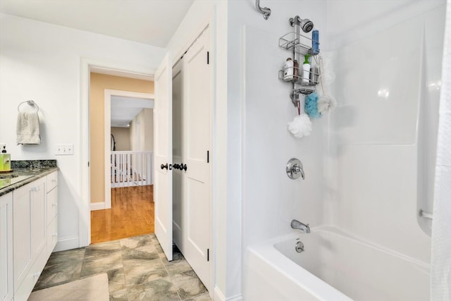 bathroom with vanity, baseboards, and shower / tub combination