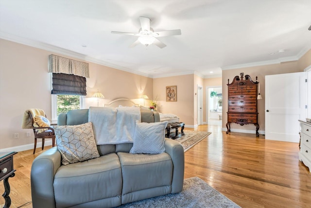 living room with crown molding, light wood finished floors, ceiling fan, and a wealth of natural light