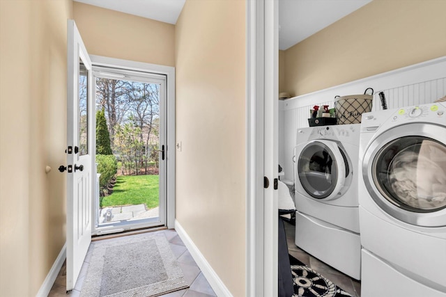 clothes washing area with tile patterned floors, baseboards, laundry area, and independent washer and dryer
