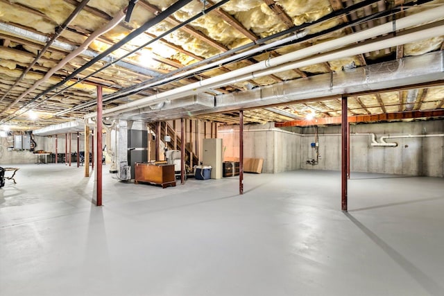 unfinished below grade area featuring stairs and heating unit