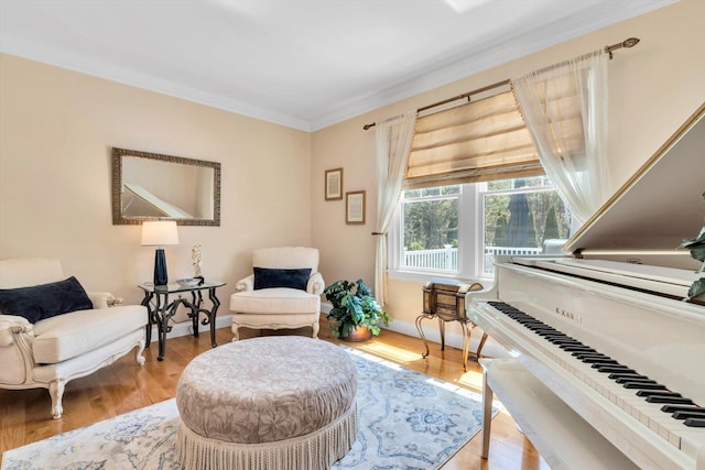 sitting room featuring baseboards, ornamental molding, and wood finished floors