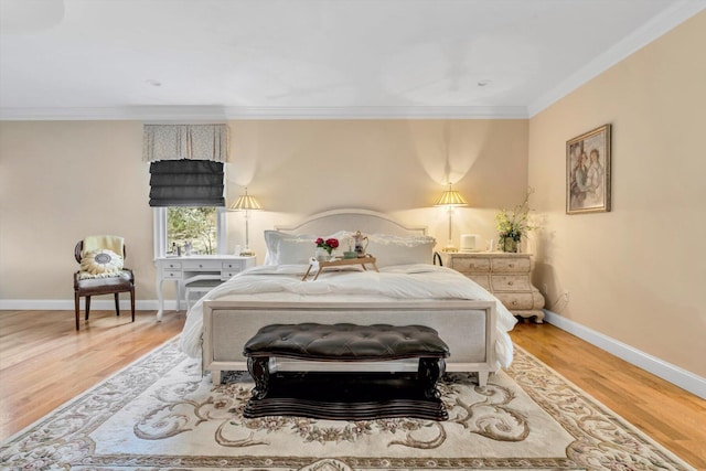 bedroom featuring baseboards, ornamental molding, and wood finished floors