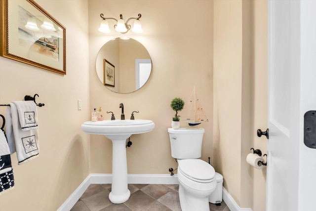half bath featuring baseboards, tile patterned flooring, and toilet