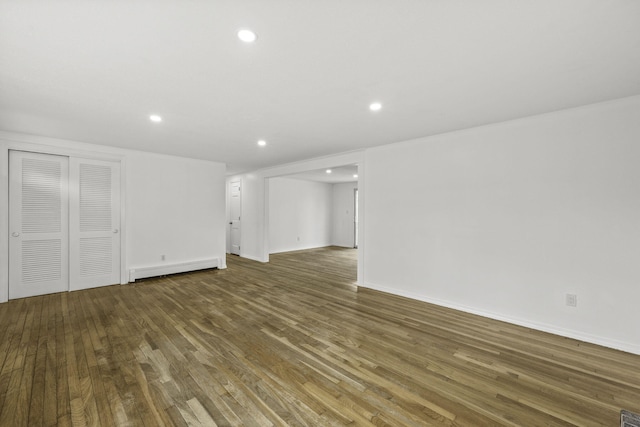 interior space featuring baseboard heating and dark hardwood / wood-style floors