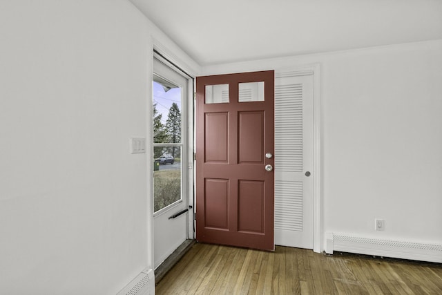 entrance foyer with wood-type flooring and a baseboard heating unit