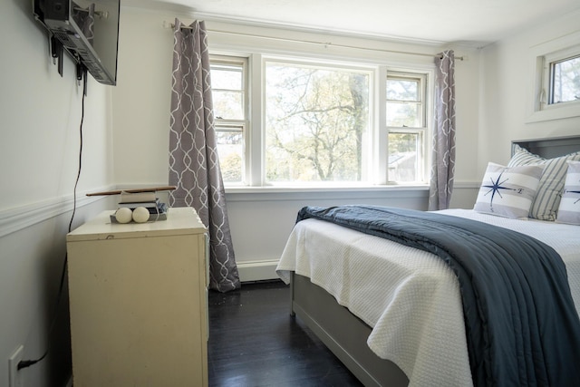 bedroom featuring dark wood-type flooring and a baseboard heating unit