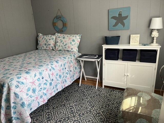 bedroom featuring wood walls and dark hardwood / wood-style floors