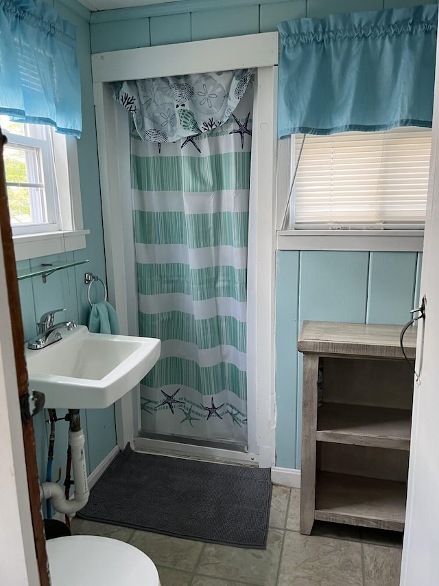 bathroom featuring toilet, a shower with curtain, and tile patterned flooring