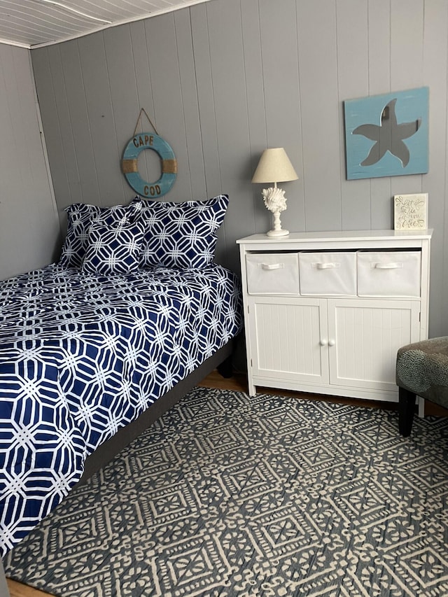 bedroom featuring wood walls