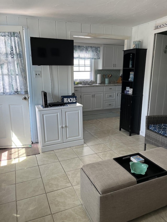 kitchen featuring light tile patterned floors, white cabinets, and sink