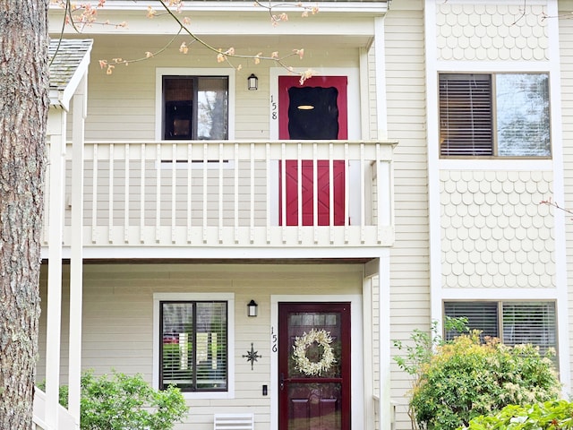 doorway to property with covered porch and a balcony