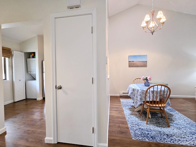 dining area with estacked washer and dryer, vaulted ceiling, wood finished floors, and a chandelier