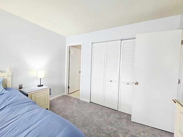 bedroom featuring light colored carpet, a closet, and baseboards