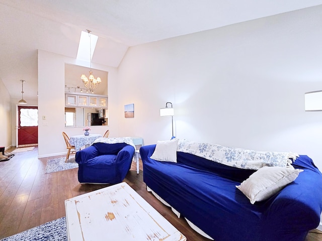 living area featuring a chandelier, vaulted ceiling, wood-type flooring, and baseboards