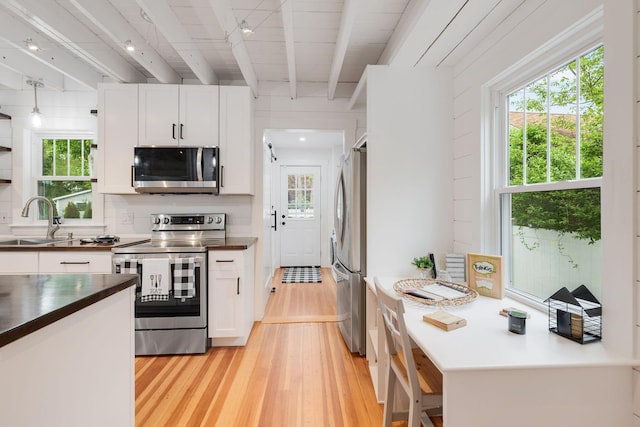 12 Dartmouth St, Hyannis, MA 02601 - kitchen featuring appliances with stainless steel finishes, a sink, light wood-style flooring, beam ceiling, and white cabinetry