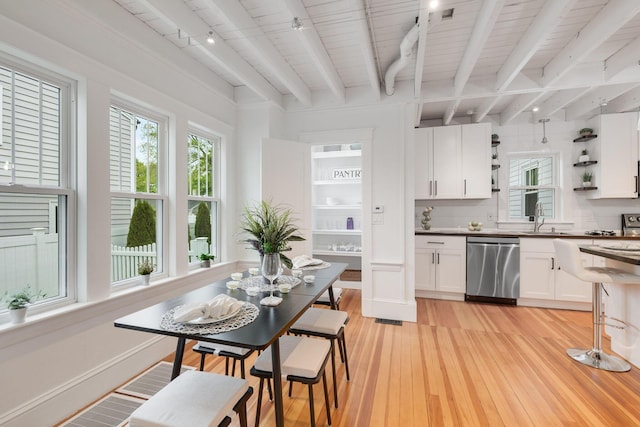 12 Dartmouth St, Hyannis, MA 02601 - kitchen with stainless steel dishwasher, rail lighting, plenty of natural light, open shelves, and beamed ceiling