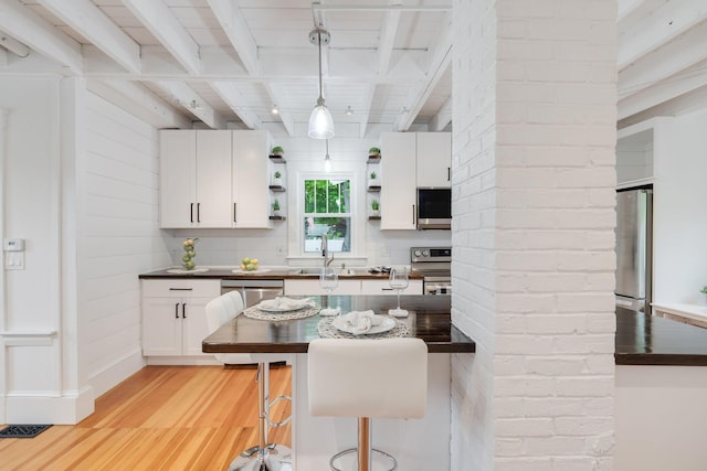 12 Dartmouth St, Hyannis, MA 02601 - kitchen featuring stainless steel appliances, light wood-type flooring, beam ceiling, open shelves, and white cabinets