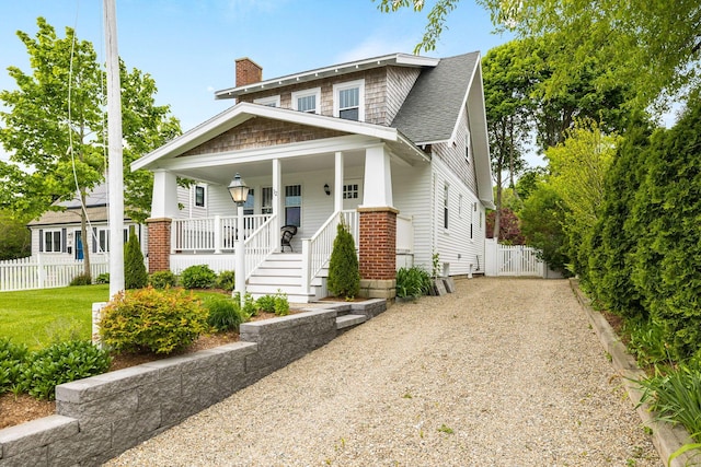 12 Dartmouth St, Hyannis, MA 02601 - view of front facade featuring a porch, driveway, a chimney, and a shingled roof