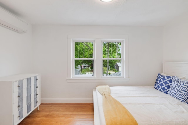 12 Dartmouth St, Hyannis, MA 02601 - bedroom with wood finished floors, a wall unit AC, and baseboards