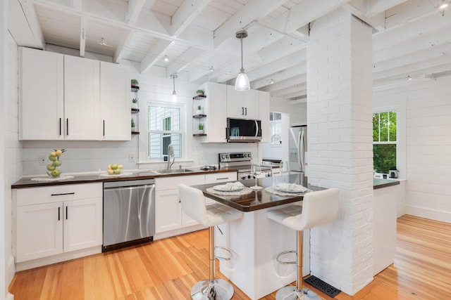 12 Dartmouth St, Hyannis, MA 02601 - kitchen with stainless steel appliances, dark countertops, light wood finished floors, open shelves, and healthy amount of natural light